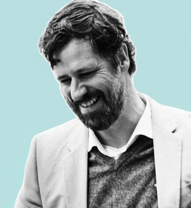Hanno Strack — Founder of Bahamas Homes Development. Monochrome portrait on the Bahamas Homes turquoise background.